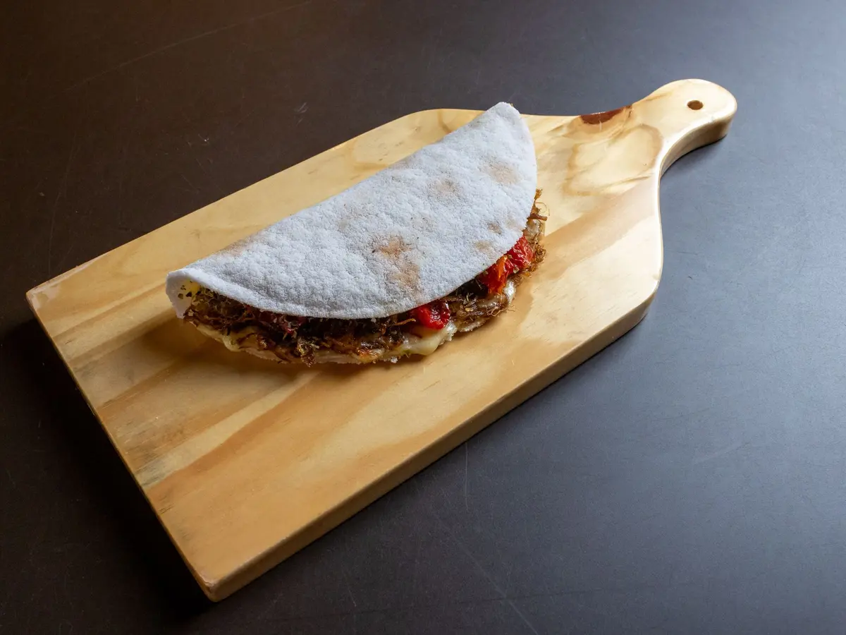 Tapioca recheada sobre uma tábua de madeira
